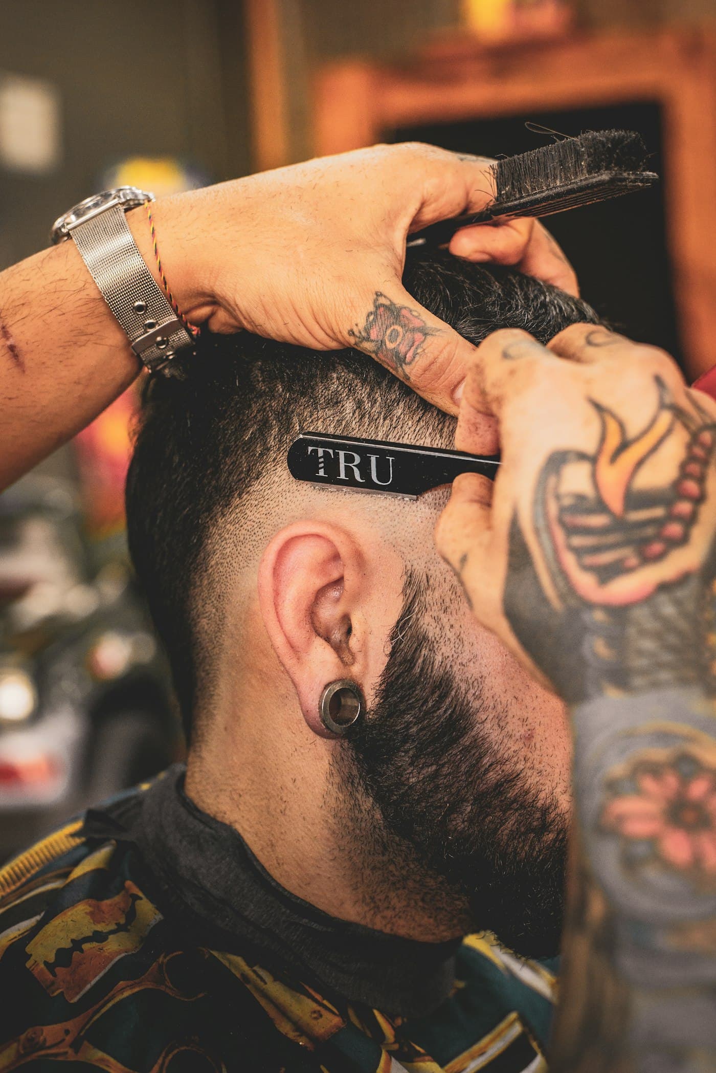 A barber shaping a customer's haircut