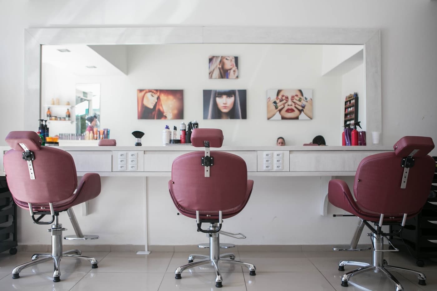 A barber finishing a customer's haircut in a busy shop